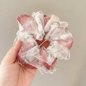 French style floral organza scrunchie with red rose print held in hand to show size
