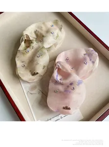 Dettaglio di eleganti mollette per capelli in rete lucida con piccoli strass fini