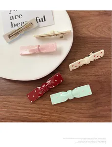 Vue détaillée de l'arrière des barrettes à pois colorés avec pinces crocodiles en argent