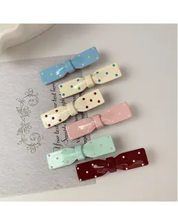Détail de six barrettes à cheveux nuds à pois colorés avec une finition en résine
