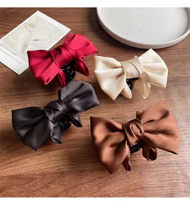 Detailed set of elegant satin bow hair claws in burgundy, cream, black, and coffee brown