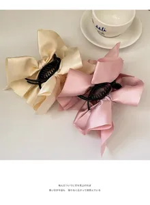 Detailansicht der übergroßen Satin-Schleifen-Haarklammern in Beige und Rosa für Stylings