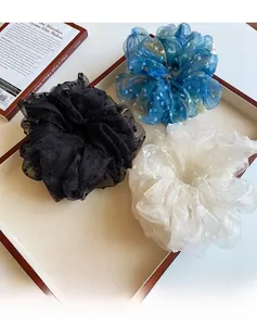 Gros plan de trois chouchous en organza noir bleu et beige à pois blancs élégants