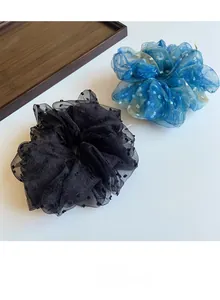 Détail de chouchous en tulle étoilé bleu et à pois noirs sur un plateau en bois