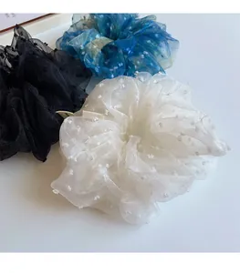 Vue macro de chouchous en organza bleu et blanc avec des pois suisses délicats