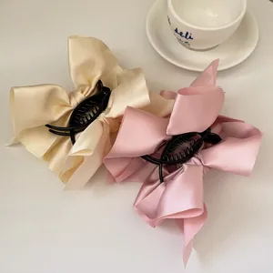 Elegante übergroße Satin-Bogen-Haarklammern in Beige und Rosa für stilvolle hohe Pferdeschwänze