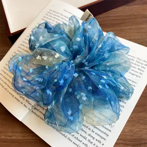 Chouchou en dentelle bleue à pois blancs posé sur un livre avec un fond en bois rustique