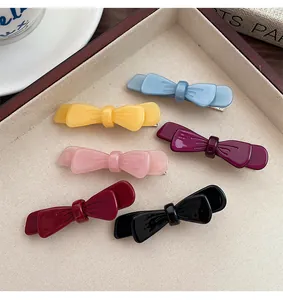 Dettaglio di sei fermagli per capelli a fiocco in acetato colorato con clip a becco in metallo