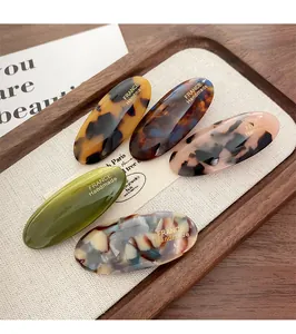 Detail of oval acetate hair clips with France Handmade gold foil on marble textures