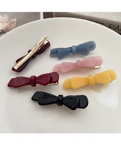 Dettaglio di fermagli per capelli a fiocco in acetato colorato nero giallo rosa