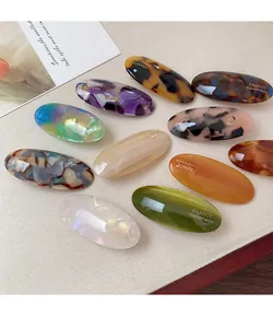 Close-up of tortoise shell and marble acetate oval hair clips with gold France handmade text