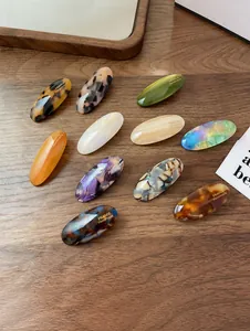 Close-up of handmade oval acetate hair clips with marbled and tortoiseshell patterns