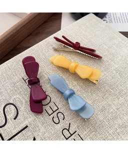 Dettaglio di un set di fermagli per capelli a fiocco in acetato con clip dorate