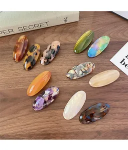 Detailed macro view of handmade oval acetate hair clips with tortoise shell textures