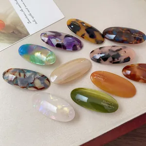 Set of 10 oval acetate hair clips in tortoiseshell and marble patterns with gold text