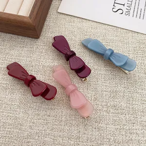 Set di fermagli per capelli a fiocco in bordeaux e colori pastello su sfondo morbido