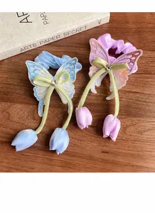 Détail de chouchous papillon brodés avec des pendentifs élégants en forme de tulipe