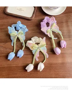 Détail de chouchous papillon brodés avec rubans de tulipes aux couleurs pastel