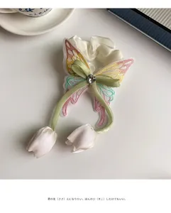 Détail de chouchou en organza avec papillon brodé et pendentifs tulipes en tissu