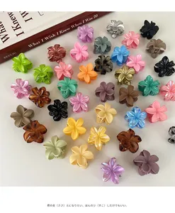 Vista plana de varias pinzas para el cabello con flores de colores sobre fondo blanco