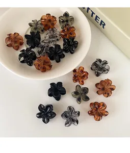 Detalle de pequeñas pinzas para el cabello con flores de resina y mármol