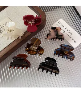 Detailed top view of assorted mini tortoise and marble acetate hair claws with gold text