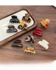 Macro view of mini leopard print acetate hair claws in various colors on a wooden tray