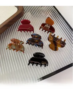Detailed macro of high-quality French acetate hair claws with handmade gold lettering