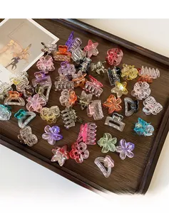 Primo piano di mollette in resina colorata a forma di fiore e cuore su vassoio in legno