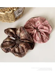 Detail of vintage plaid fabric scrunchies with brand label and premium edge stitching