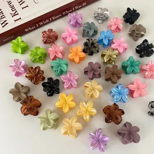 Mini pinzas para el cabello con flores en varios colores sobre un fondo blanco