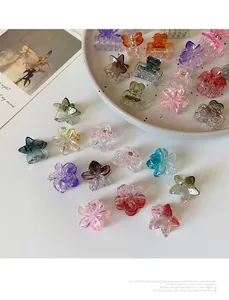 Dettaglio di piccoli fermagli per capelli in acrilico colorato a forma di fiore e stella