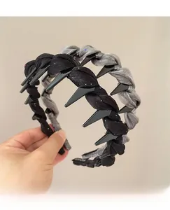 Détail d'un serre-tête en tissu tissé avec pointes noires antidérapantes en argent et noir