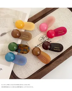 Detailed close-up of handmade resin hair clips in various Morandi colors on a canvas tray
