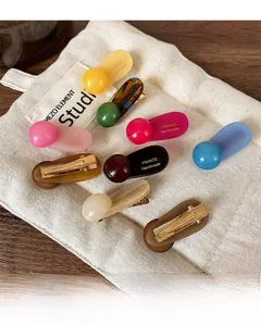 Detail view of colorful ball hair clips featuring FRANCE Handmade engraved text