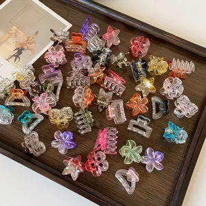 Mini mollette per capelli in resina colorata con fiori e stelle su vassoio in legno