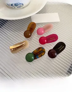 Close-up of a 6-piece colorful resin ball hair clip set with golden metal duckbill base