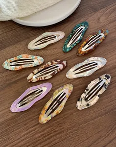 Macro shot of 9-piece acetate hair clips with marble texture on vintage wooden background