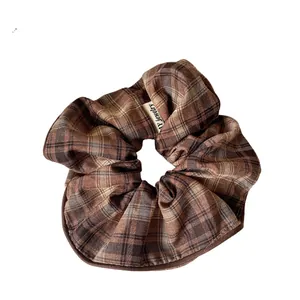 Retro brown plaid fabric scrunchie with AY jewelry tag shown on a clean white background