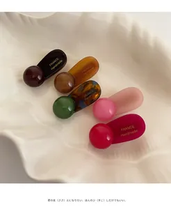 Detailed view of handmade resin hair clips set in marble and solid colors with gold lettering