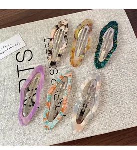 Close-up of six acetate hair clips with marble patterns and tortoiseshell textures