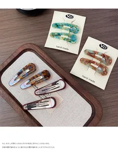 Detail view of French vintage teardrop snap clips in marble and tortoiseshell patterns