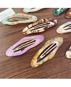 Detail of colorful acetate cloud hair clips with marble texture on a wood surface