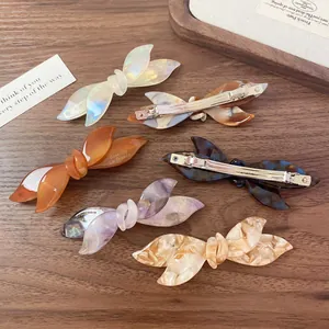 Elegant bow-shaped acetate hair clips set in marble and tortoiseshell patterns