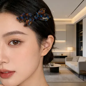 Elegant tortoiseshell acetate bow hair clip with Bonette metal lettering on a model