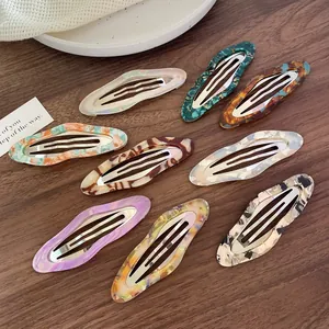 9-piece set of cloud-shaped acetate hair clips with marble patterns on wood background