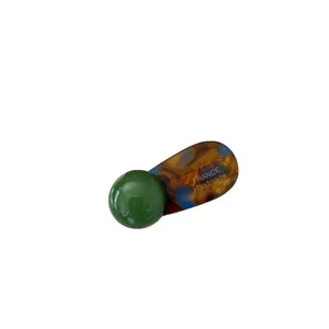 Handmade emerald green and amber acetate hair clip with sphere detail on white background