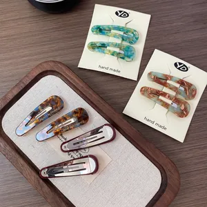French vintage acetate hair clips with marble patterns and Creation France logo engraving