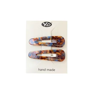 French retro tortoiseshell hair clips with blue and amber marble pattern on card