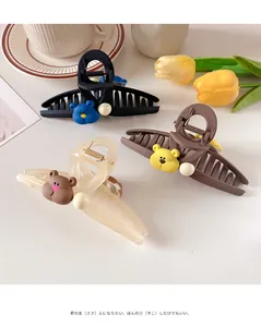Detail of large hair clips with cute 3D bear icons in black, mocha, and cream white